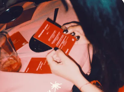 Chica leyendo una tarjeta roja en una mesa